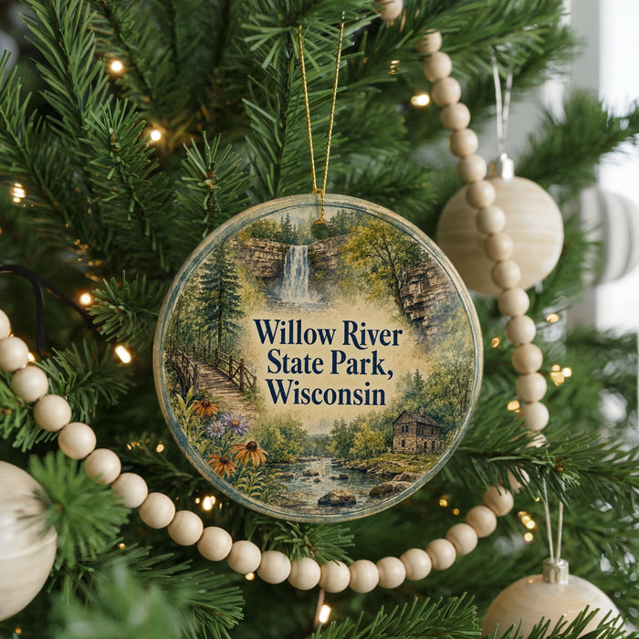 A round ornament hanging on a Christmas tree, featuring a scenic image of Willow River State Park in Wisconsin.