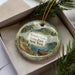 A decorative ornament with a scenic image of Wonder Lake State Park in New York, featuring a canoe and a mountain landscape.