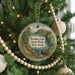 A round ornament on a Christmas tree, featuring a scenic landscape with a lake, mountains, and a red boat, with the text "Wonder Lake State Park, New York" displayed on it.
