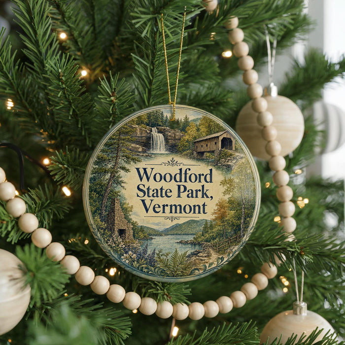 A circular ornament hanging on a Christmas tree, featuring a scenic image of Woodford State Park in Vermont.