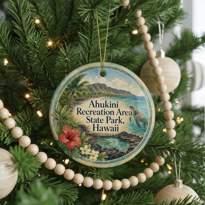 A round ornament hanging on a Christmas tree, featuring a tropical landscape with palm trees, a beach, and a mountain range.