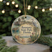 A round ornament with a beach scene and a bird, featuring the text "Anastasia State Park, Florida" on it, is displayed on a table with pine branches in the background.