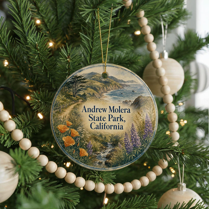 A round ornament hanging on a Christmas tree, featuring a scenic landscape of mountains, trees, and a river.