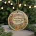 A decorative ornament featuring a desert landscape with mountains, cacti, and a bighorn sheep, hanging from a string.