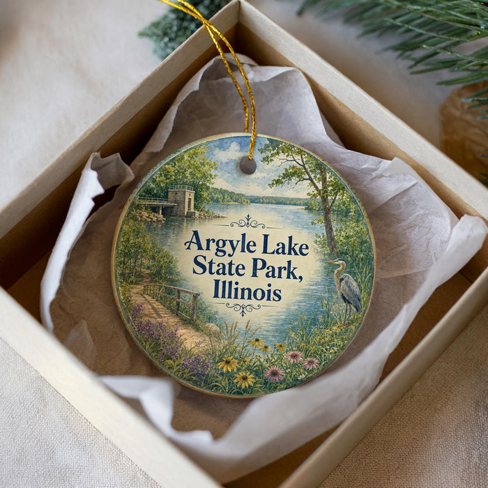 A decorative ornament in a box, featuring a scenic image of Argyle Lake State Park, Illinois.