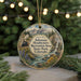 A decorative ornament featuring a scenic landscape with mountains, a waterfall, and a train, hanging from a string.