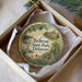 A decorative ornament in a box, featuring a scenic landscape with a house, trees, and a bird, along with the text "Bellevue State Park, Delaware".