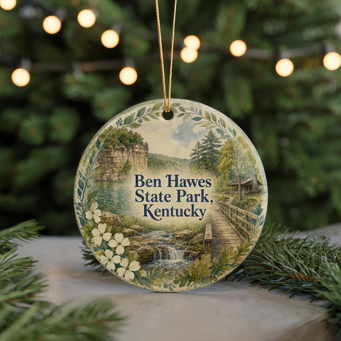 A round ornament with a scenic landscape of Ben Hawes State Park, Kentucky, featuring a waterfall and a wooden bridge.