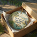 A decorative ornament in a box, featuring an illustration of a seagull, a turtle, and palm trees, with the text "Big Lagoon State Park, Florida" printed on it.