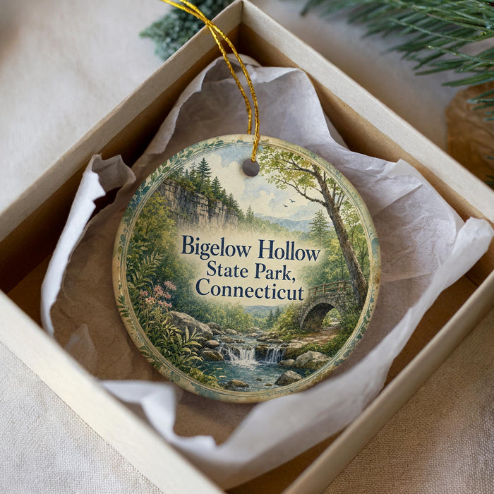 A round ornament with a scenic landscape of Bigelow Hollow State Park in Connecticut, featuring a waterfall and forest.