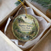 A round ornament with a scenic landscape of Bigelow Hollow State Park in Connecticut, featuring a waterfall and forest.