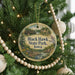 A round ornament hanging on a Christmas tree, featuring a scenic image of Black Hawk State Park, Iowa.