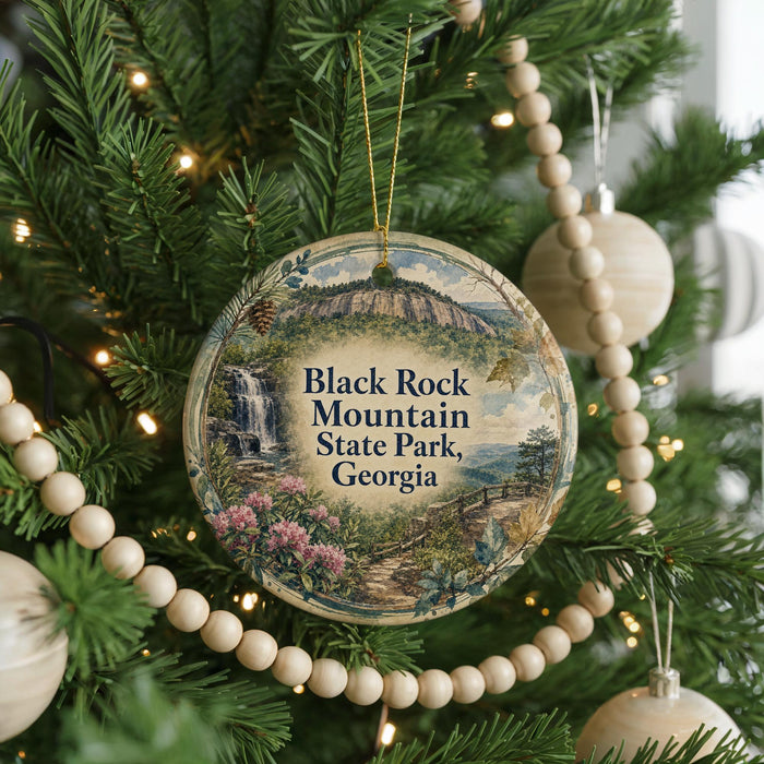 A round ornament hanging on a Christmas tree, featuring a scenic image of Black Rock Mountain State Park, Georgia.