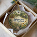 A round ornament with a scenic image of the Blackwater River, State Park, Florida, hanging from a string.