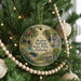 A round ornament hanging on a Christmas tree, featuring a scenic image of Bladon Springs State Park, Alabama.