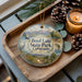 A wooden tray with a decorative ornament featuring a scenic landscape of Boyd Lake State Park, Colorado, along with pine cones and a lit candle.