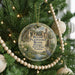 A round ornament hanging on a Christmas tree, featuring an illustration of a bird and palm trees, with text that reads "Bulow Plantation Ruins Historic State Park, Florida".