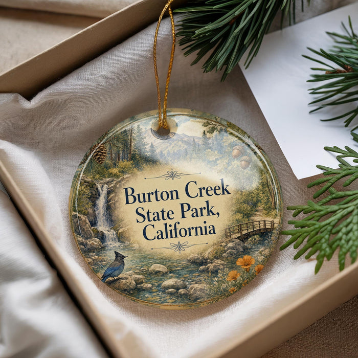 A round ornament with a scenic image of a waterfall and forest, hanging from a string.