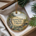 A round ornament with a scenic image of a waterfall and forest, hanging from a string.