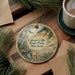 A decorative ornament featuring a scenic landscape of Calvert Cliffs State Park, Maryland, with a bird in flight and a pine tree in the background.