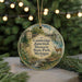 A round ornament with a scenic illustration of a deer, a bridge, and a house, surrounded by greenery and a string of lights.