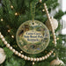 A round ornament hanging on a Christmas tree, featuring a scenic image of the Carter Caves State Resort Park in Kentucky.