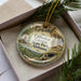 A decorative ornament in a box, featuring an illustration of the Cathedral Caverns State Park in Alabama.