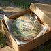 A decorative ornament in a box, featuring illustrations of a beach, palm trees, and wildlife, with the text "Cayo Costa State Park, Florida" printed on it.