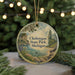 A round ornament with a scenic landscape of Cheboygan State Park, Michigan, featuring a lake, mountains, and pine trees.