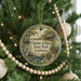 A round ornament hanging on a Christmas tree, featuring a scenic image of Chemin-A-Haut State Park in Louisiana.