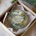 A decorative ornament in a box, featuring a scenic landscape with a lake, mountains, and a bird, along with the text "Cherry Creek State Park, Colorado".