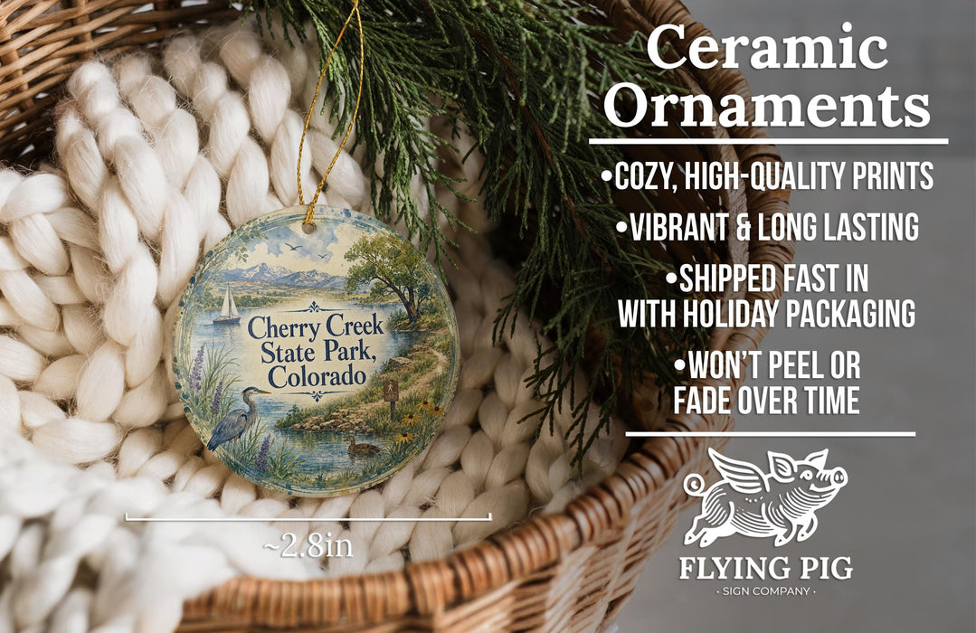 Ceramic ornaments, featuring a round ornament with a scenic landscape of Cherry Creek State Park, Colorado, hanging from a wicker basket.