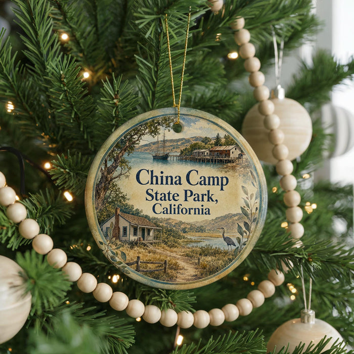 A round ornament hanging on a Christmas tree, featuring a scenic image of China Camp State Park, California.