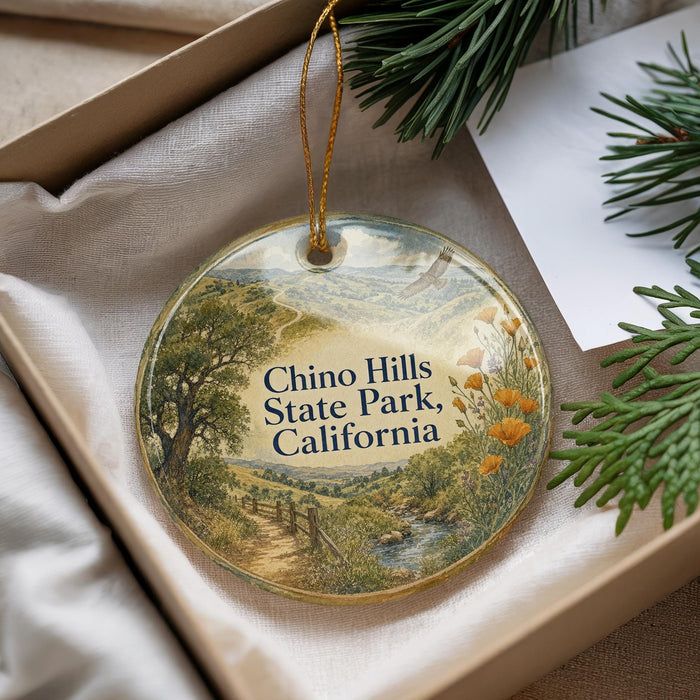 A decorative ornament with a scenic landscape of Chino Hills State Park, California, featuring a winding path, trees, and a river.