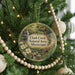 A round ornament hanging on a Christmas tree, featuring a scenic image of Clark Creek Natural Area in Mississippi.