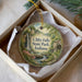 A round ornament with a scenic image of Clifty Falls State Park, Indiana, displayed in a box.