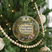 A round ornament hanging on a Christmas tree, featuring a scenic image of the Connecticut State Forest.