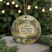 A round ornament with a scenic landscape and text that reads "Colis P. Huntington State Park, Connecticut" is displayed on a table with pine branches in the background.