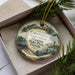 A decorative ornament in a box, featuring an illustration of the Florida State Park Museum and the words "Constitution Convention Museum" on it.