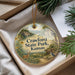 A decorative ornament with a scenic landscape of Crawford State Park, Kansas, featuring a deer, a bird, and a house, hanging from a string.