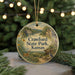 A round ornament with a scenic landscape of Crawford State Park, Kansas, featuring a deer, a bird, and a house, surrounded by greenery and a string of lights.
