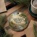 A decorative ornament with a scenic landscape of Cross Timbers State Park, Kansas, featuring a river, trees, and a bridge.