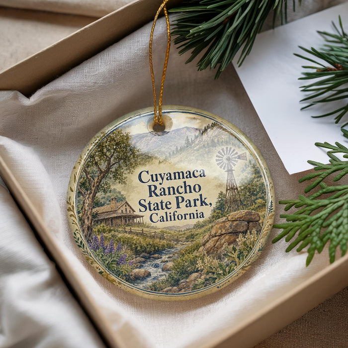 A decorative ornament with a scenic landscape of Cuyama Canyon Rancho State Park, California, featuring a windmill and mountains in the background.