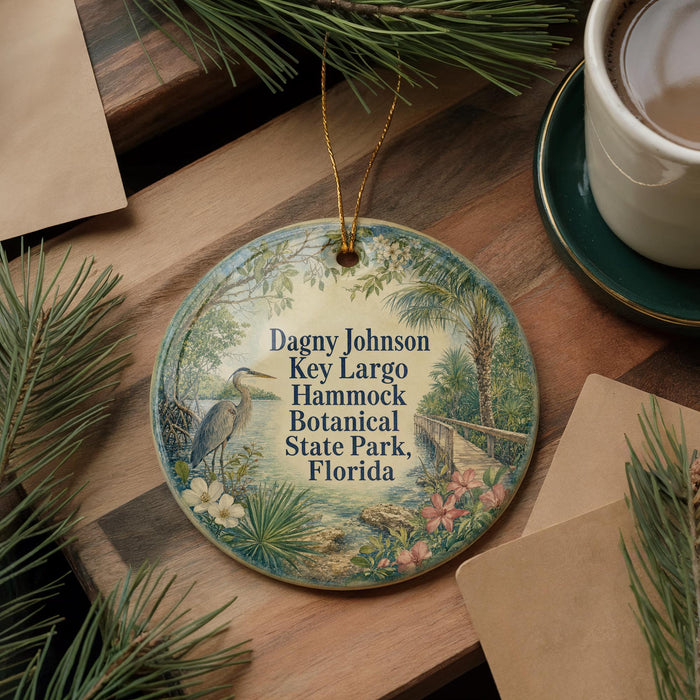 A decorative ornament with a bird and tropical plants, placed on a wooden surface next to a cup of coffee and some papers.