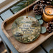 A decorative ornament with a scenic illustration of Delta Heritage Trail State Park in Arkansas, featuring a house, a river, and pine cones.