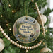 A round ornament hanging on a Christmas tree, featuring a scenic image of Denali State Park in Alaska.