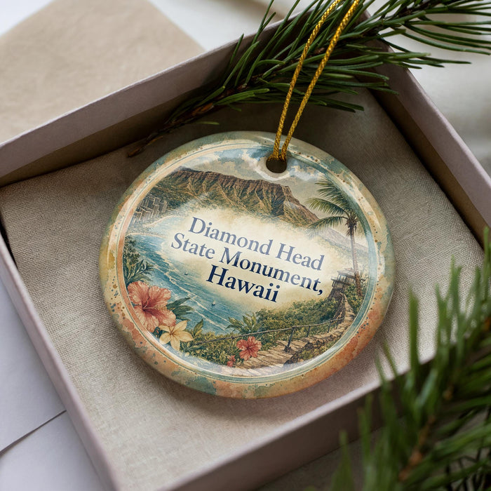 A decorative ornament in a box, featuring a tropical landscape with palm trees and a mountain range.