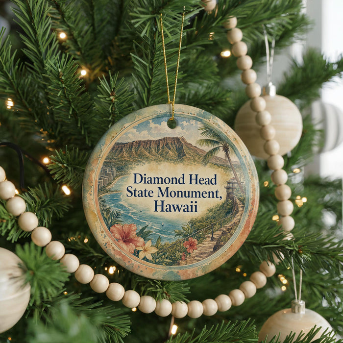 A round ornament on a Christmas tree, featuring a scenic image of Diamond Head State Monument in Hawaii.