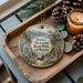 A wooden tray with a decorative ornament featuring a scenic landscape of Donner Memorial State Park, California, and a candle on a table.