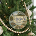 A round ornament hanging on a Christmas tree, featuring a lighthouse and a bird, with text that reads "Dr. Julian G. Bruce St. George Island State Park, Florida".